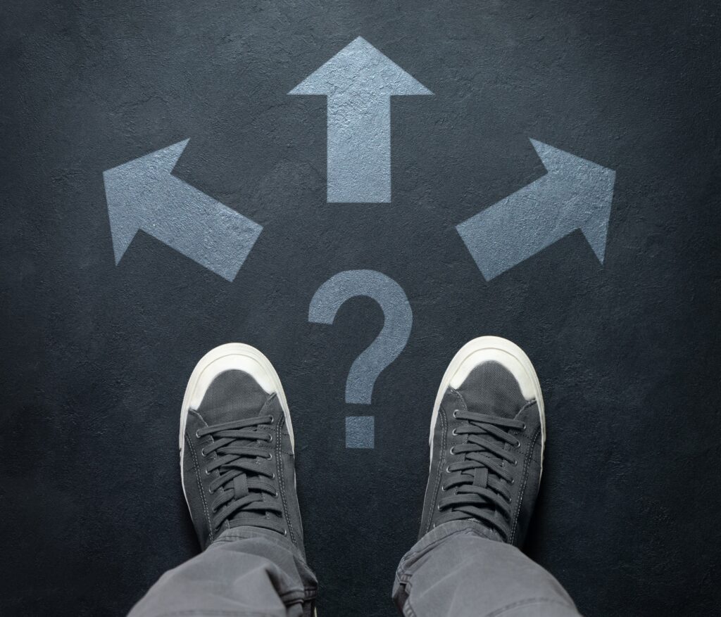 A person standing at a crossroads choosing between three directions, symbolizing the decision of finding the best dentist in Encinitas, CA. Encinitas Dental Art helps patients navigate their dental care choices with expert guidance and comprehensive services.