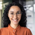 Close up photo portrait of beautiful Latin American woman with curly hair and glasses